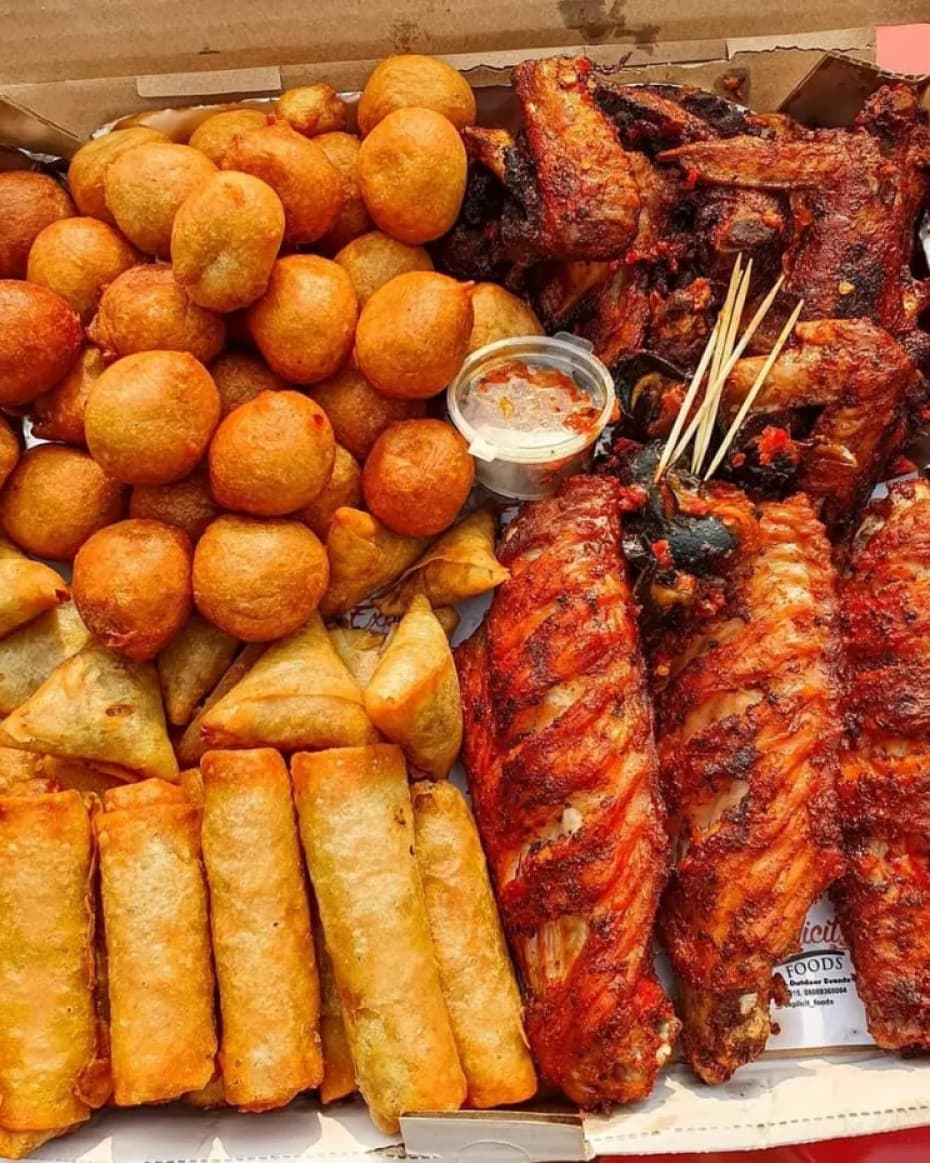 Nigerian small chops platter with puff puff samosas spring rolls and peppered meat for events